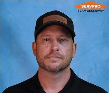 male employee in a black SERVPRO shirt and hat