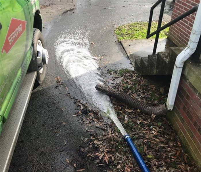 a stream of water coming from a hose and going down the driveway