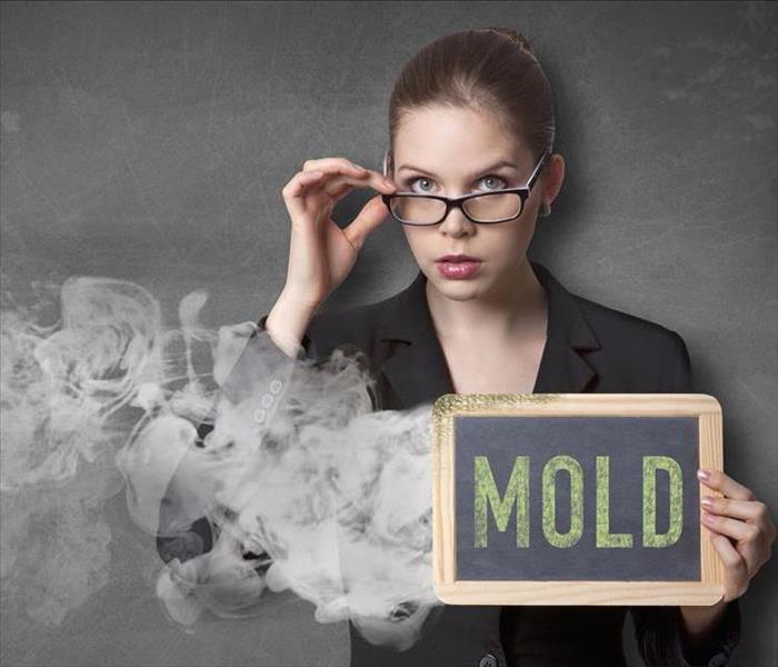 female holding a mold sign